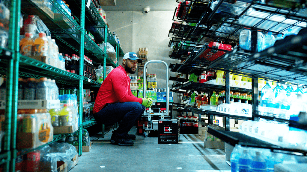 A-Photo-Of-A-Delivery-Driver-Squatting-Down-In-Convenience-Store-Loading-Shelves